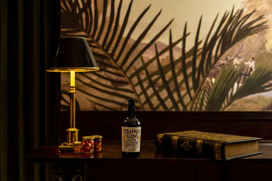 Gin bottle under a palm-print wall